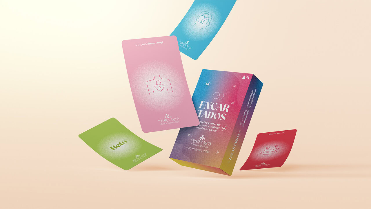 Cartas del juego de cartas 'Encartados' desplegadas, mostrando diferentes colores (rosa, azul, verde, rojo) y gráficos minimalistas. El diseño de cartas incluye la caja del juego, parte del branding general.