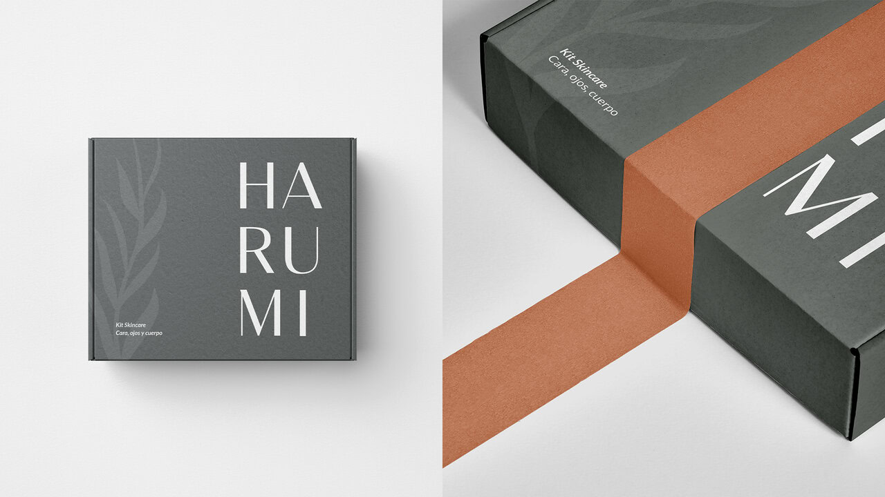 Cajas de productos Harumi, mostrando el diseño de empaque minimalista. Color gris oscuro con el logotipo y una ilustración de hojas. Branding para cosmética natural.