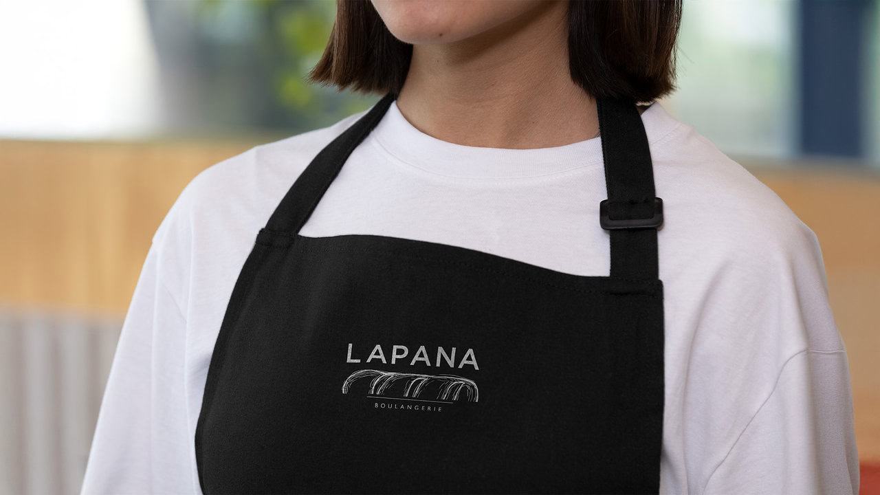 Mandil negro con el logotipo de LAPANA bordado en blanco. Diseño de uniforme para panadería artesanal.