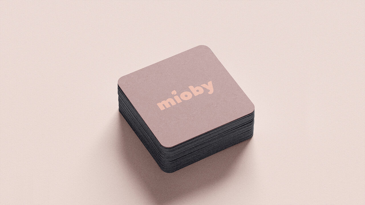 Conjunto de tarjetas de presentación cuadradas de Mioby. Diseño en color rosa oscuro con el logotipo de la marca en color rosa claro. Papelería corporativa.