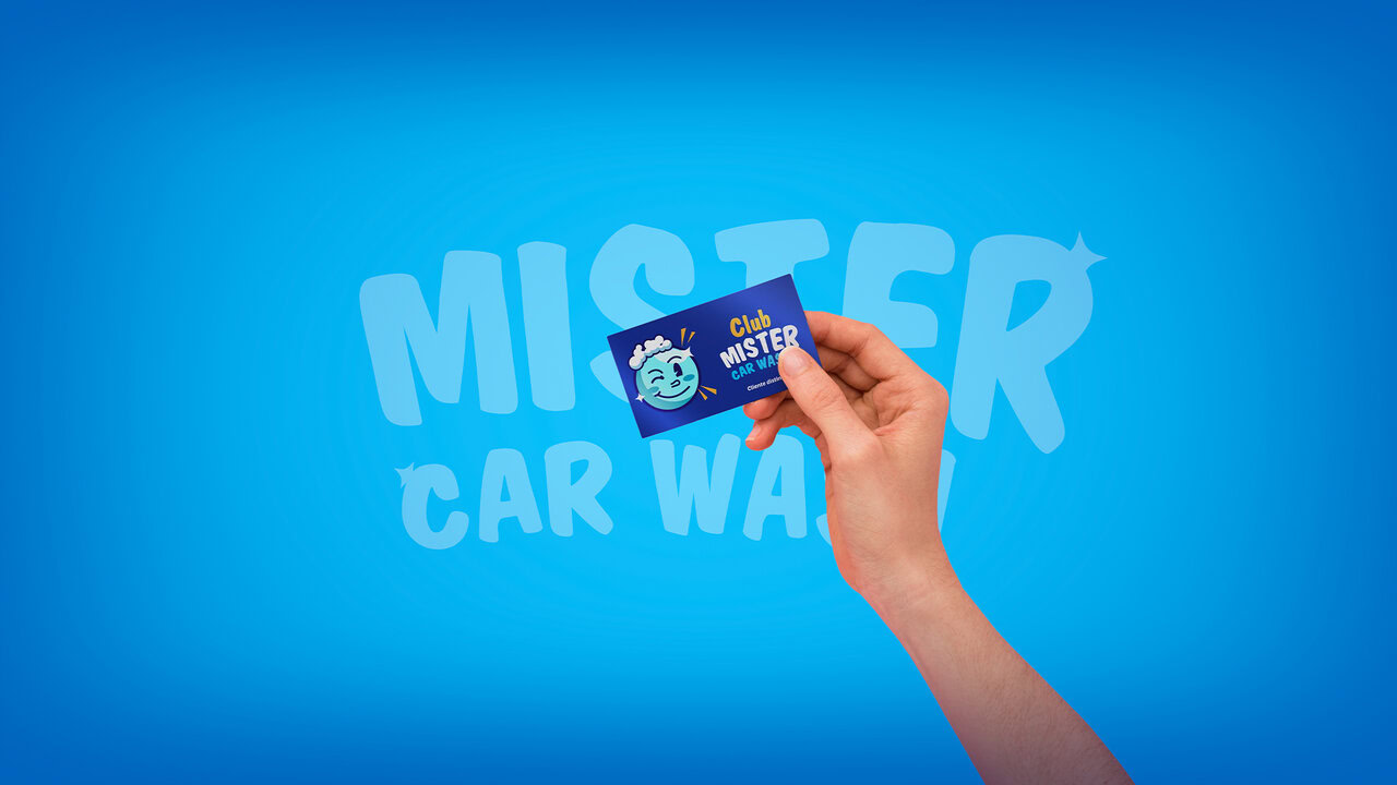 Mano sosteniendo una tarjeta de lealtad del autolavado, fondo azul con las palabras mister car wash en azul mas claro.