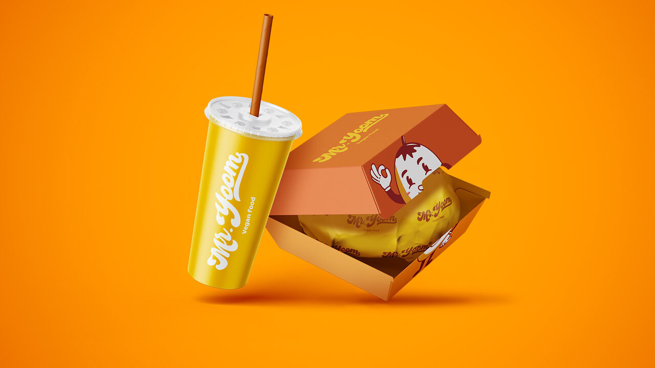 Vaso de bebida de comida rápida y empaque de hamburguesa, flotando sobre fondo naranja.